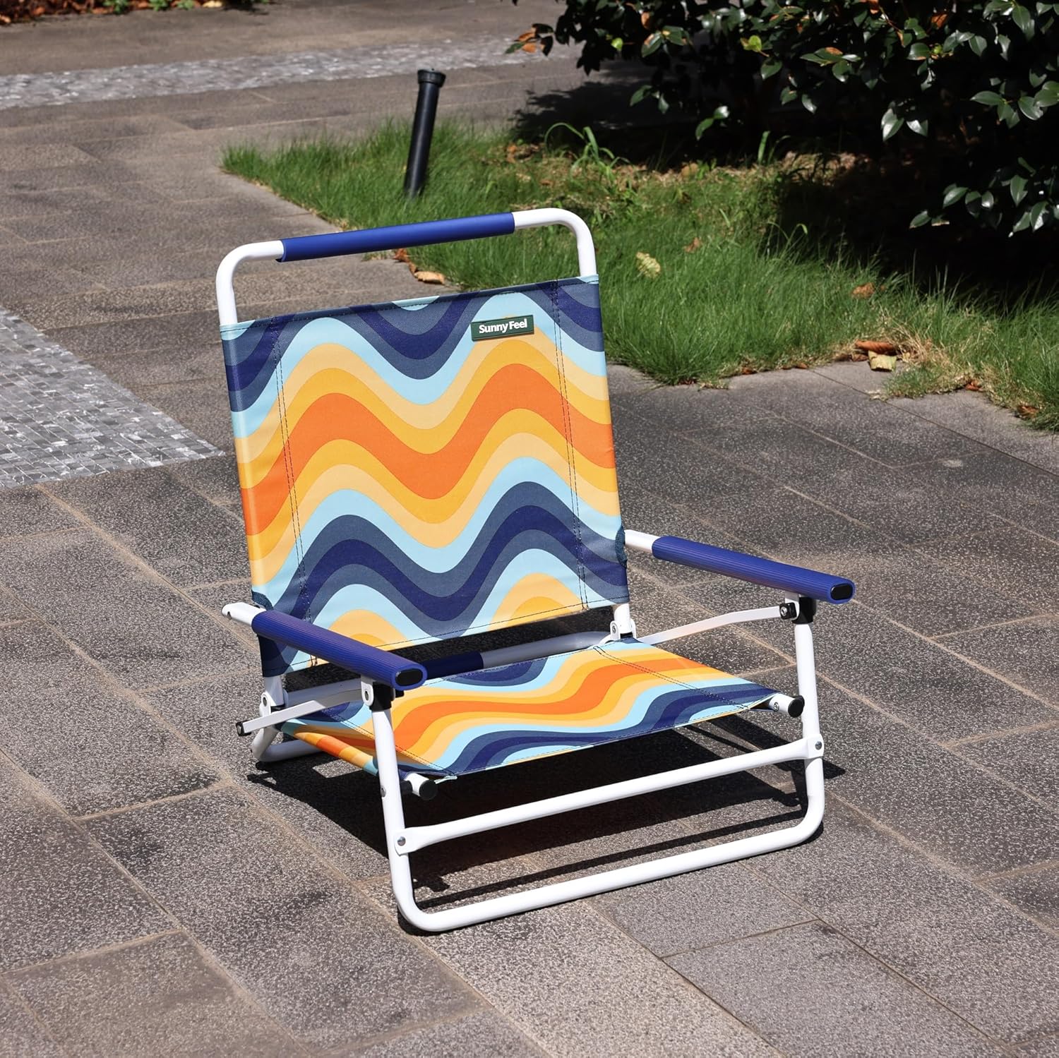 Colorful beach chair with wave pattern on a paved surface