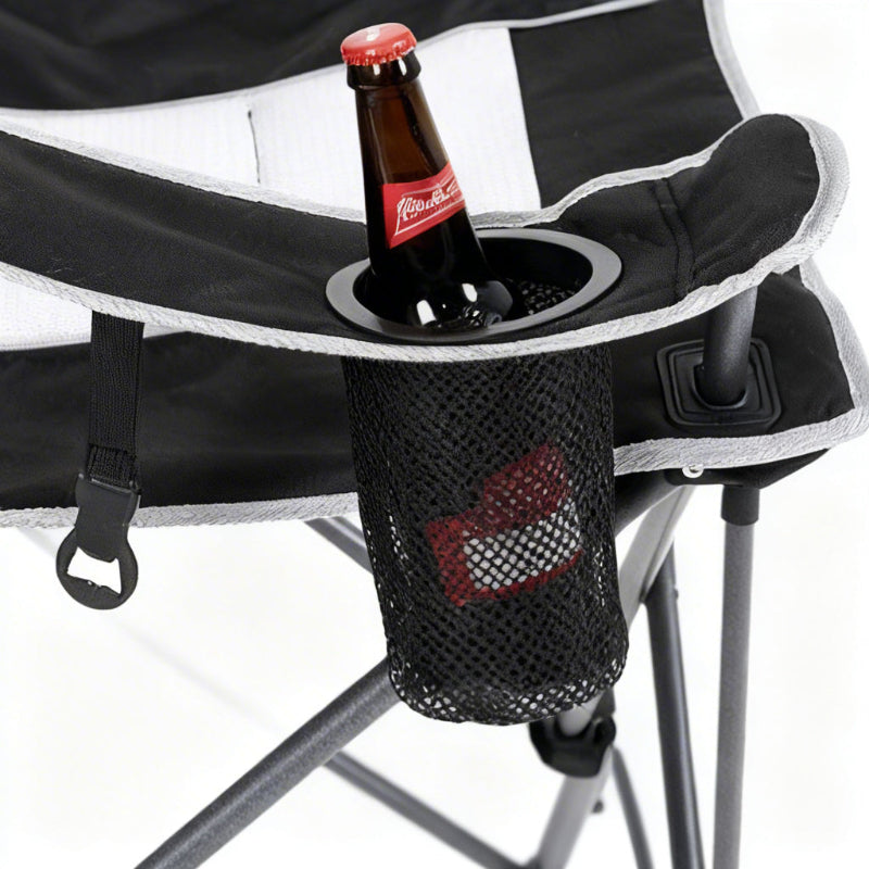 Black camping chair with a built-in cup holder containing a bottle of beer.