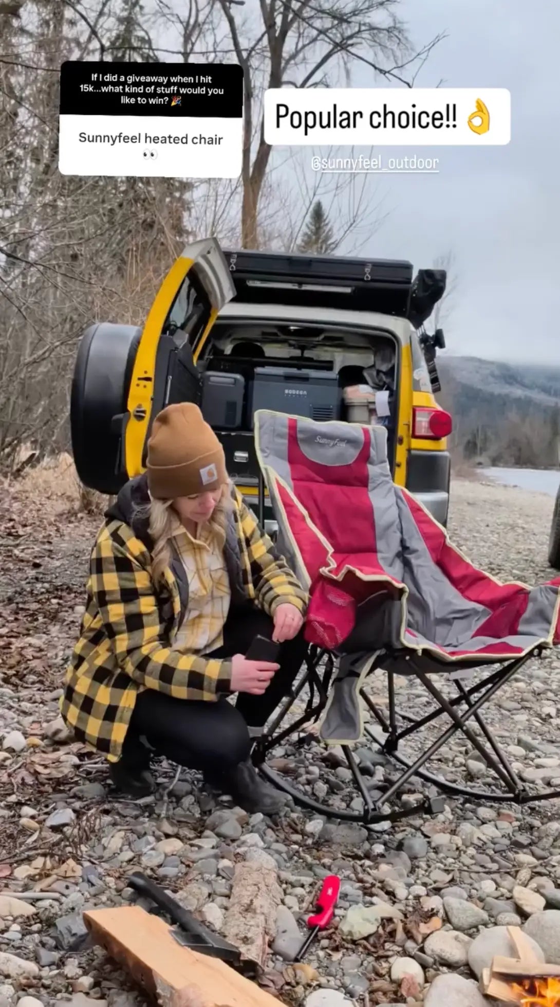 Person sitting on a folding chair next to an open car trunk with a scenic background