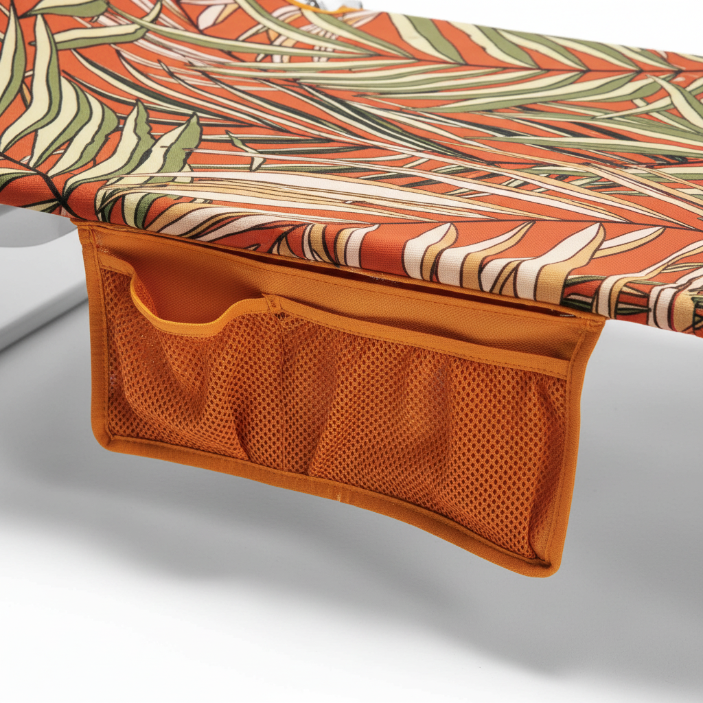 Chaise lounge with tropical patterned cushion and orange side pocket on a white background