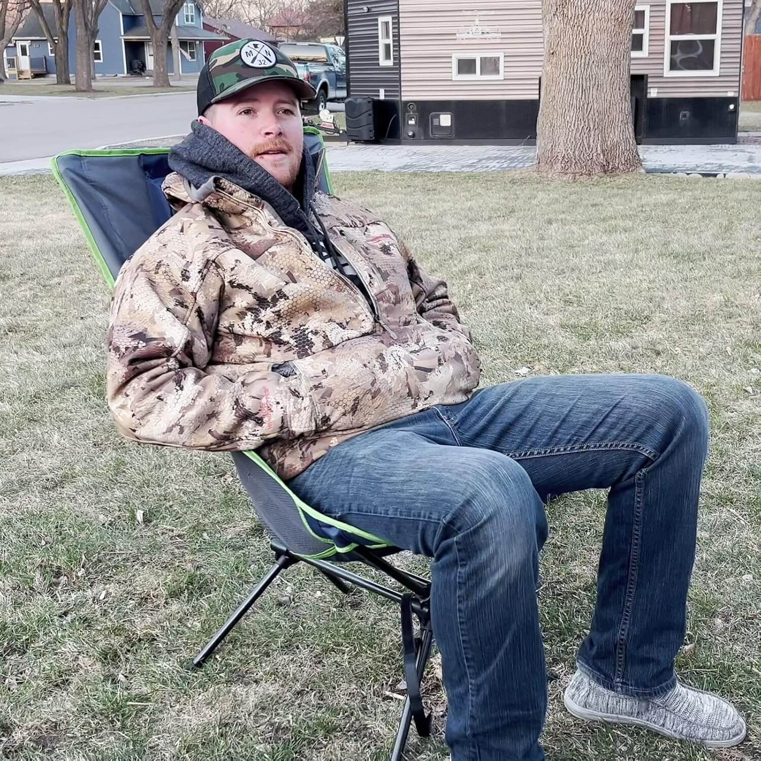 Man sitting on a folding chair outdoors in a residential area