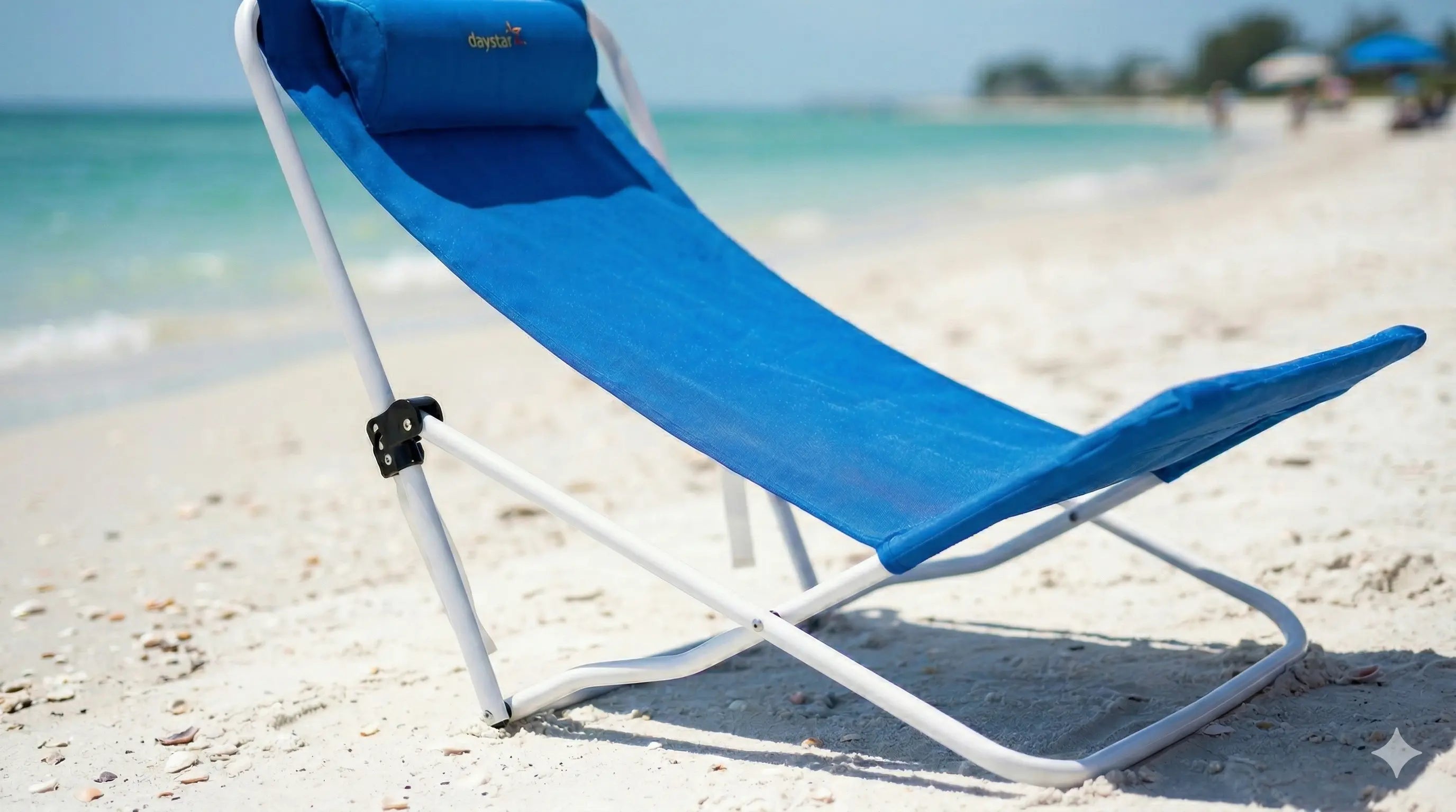Blue beach lounge chair on a sandy beach with ocean in the background