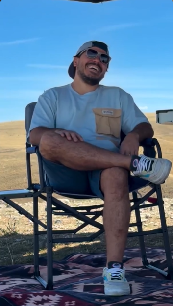 Man sitting on a chair outdoors with a clear blue sky