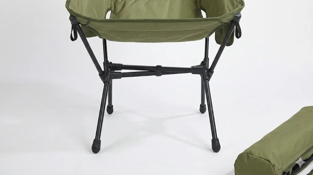 Green camping chair with a black frame on a white background