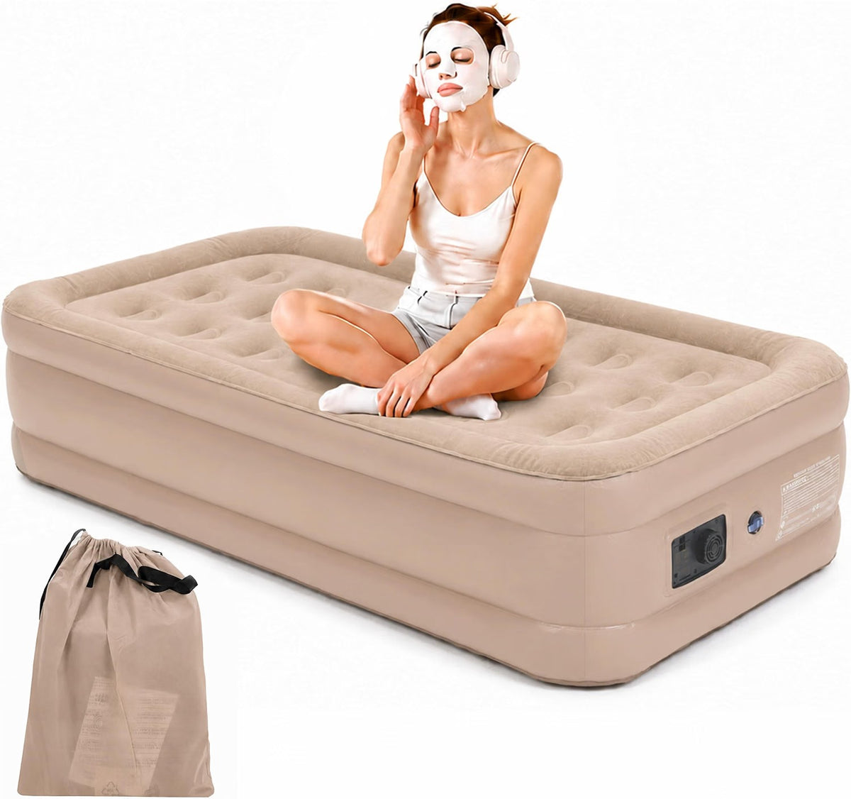 A woman sits cross-legged on a beige inflatable camping bed with a white sheet covering her face, while wearing white headphones. A matching beige drawstring storage bag is shown in the lower-left corner against a plain white background.