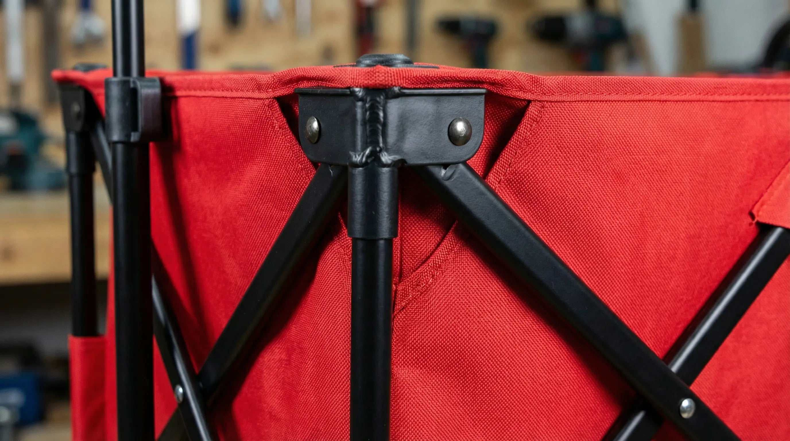 Red folding chair with black metal frame in a workshop setting